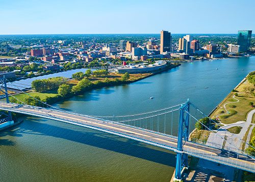 aerial view of blue suspension bridge and Toledo skyline over Maumee River